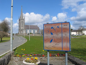 All this nice, green grass and there's no kids around tearing it up playing football? Irish kids are boring. Lawn and church and sign at Mullingar.